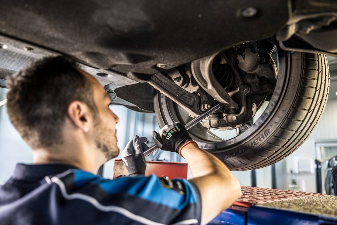 Prüfer kontrolliert Achse und Fahrwerk an einem Rad